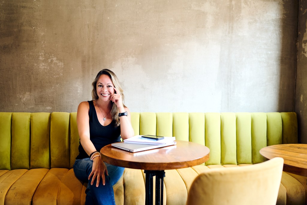 Leah sitting at a table and on a green couch 